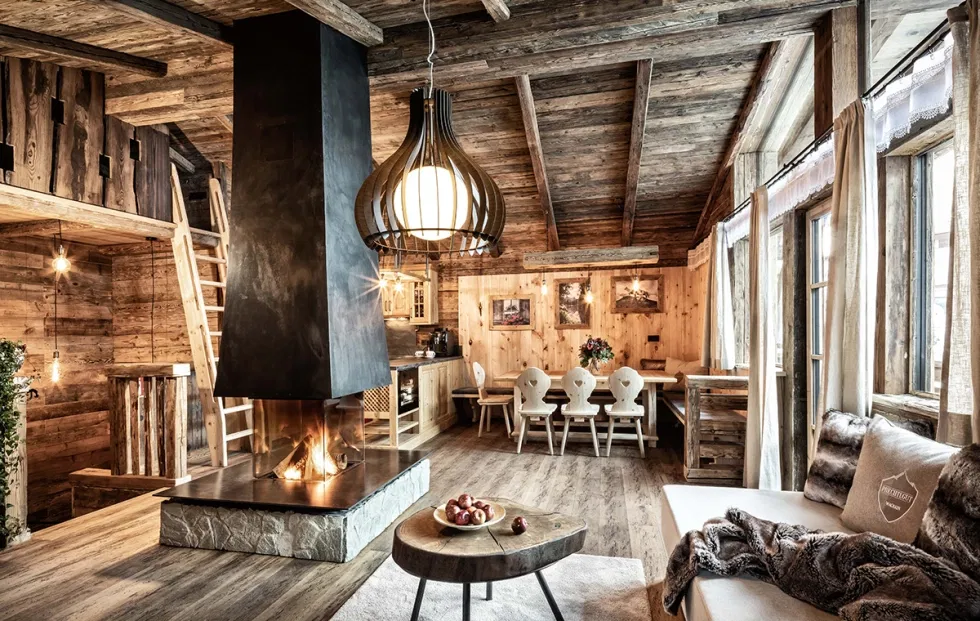 Gemütliche Chalet-Stube mit offenem Kamin, rustikaler Holzeinrichtung und stilvollem Alpenflair im Bergdorf Prechtlgut.