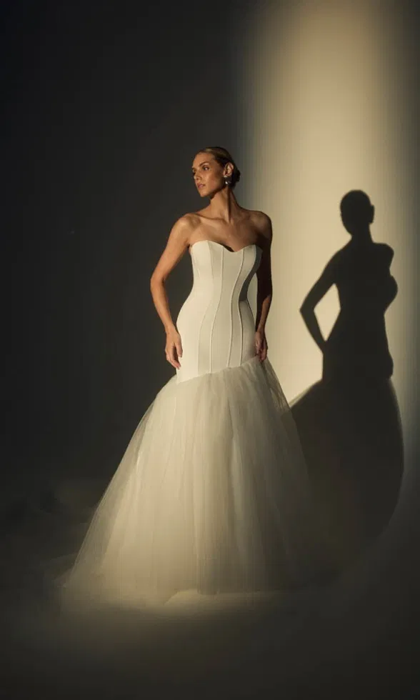 Schlichtes, elegantes Brautkleid mit herzförmigem Ausschnitt und Tüllrock, inszeniert im Studio-Lichtspiel.