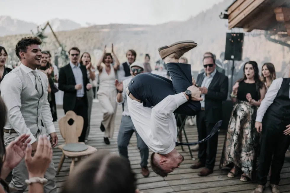 Ein Gast zeigt einen spektakulären Überschlag auf der Tanzfläche, während die Hochzeitsgesellschaft begeistert jubelt.