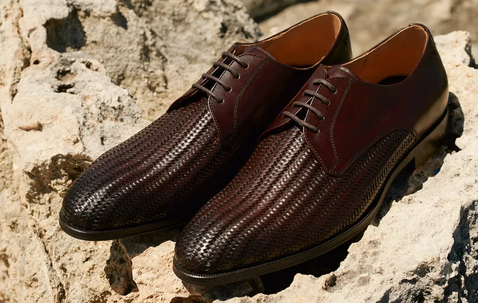 Braune geflochtene Leder-Herrenschuhe von Digel, hochwertig inszeniert auf Felsen, ideal als elegante Schuhe für Bräutigam-Looks oder sommerliche Hochzeitsoutfits.