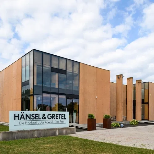 Moderne Außenansicht von Hänsel & Gretel, exklusives Hochzeits- und Brautmodenhaus mit zeitgenössischer Architektur und Glasfassade.