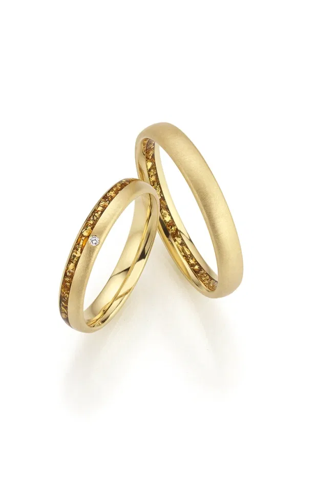 Fischer Trauringe aus Gelbgold mit eingearbeiteten Gold Flakes, mattierte Oberfläche mit lebendiger, eleganter Struktur.