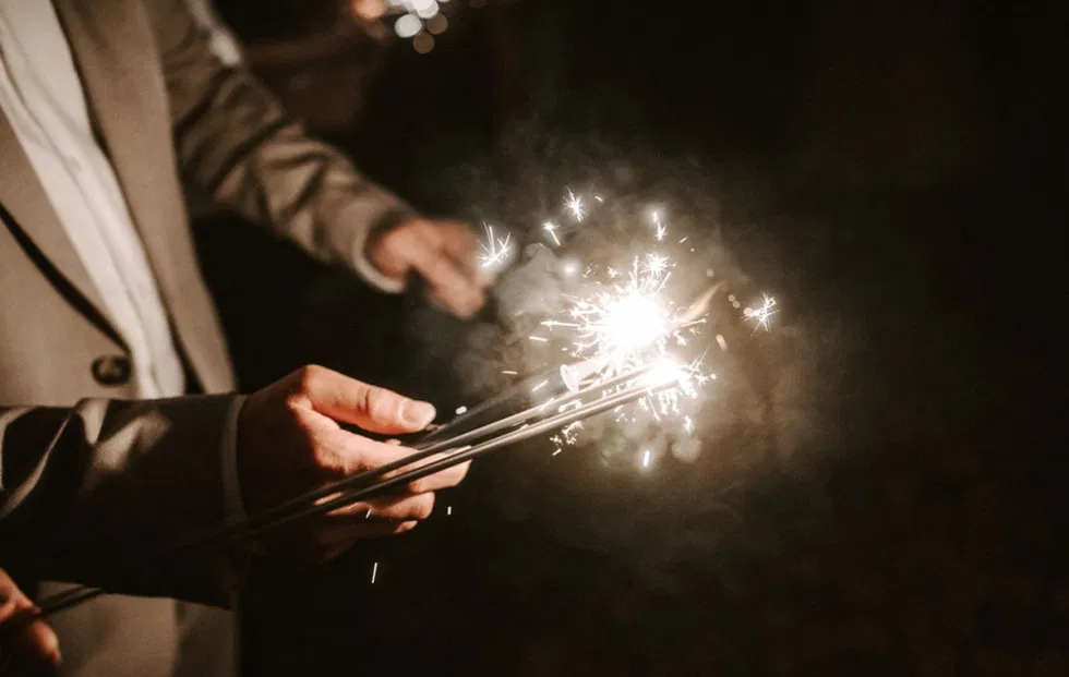 Wunderkerzen werden entzündet und leuchten in der Dunkelheit – stimmungsvolles Detail für einen besonderen Abschluss der Hochzeitsfeier.