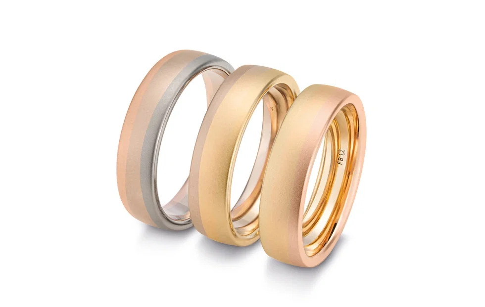 Ombre-Trauringe von Saint Maurice mit sanften Farbverläufen in Gelbgold, Roségold und Weißgold.