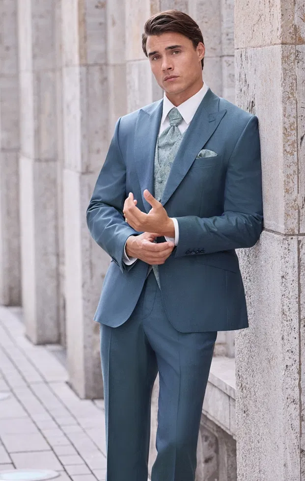Bräutigam im petrolfarbenen Hochzeitsanzug mit gemusterter Krawatte – edler Stil für moderne Hochzeiten.