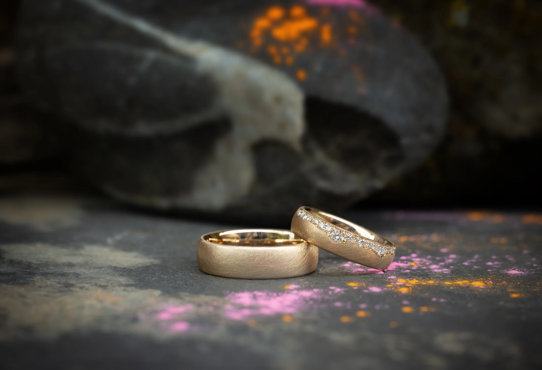 Individuelle Trauringe aus Gold mit Diamantbesatz auf dunklem Hintergrund – handgefertigt in der Trauringmanufaktur Birte Schumacher