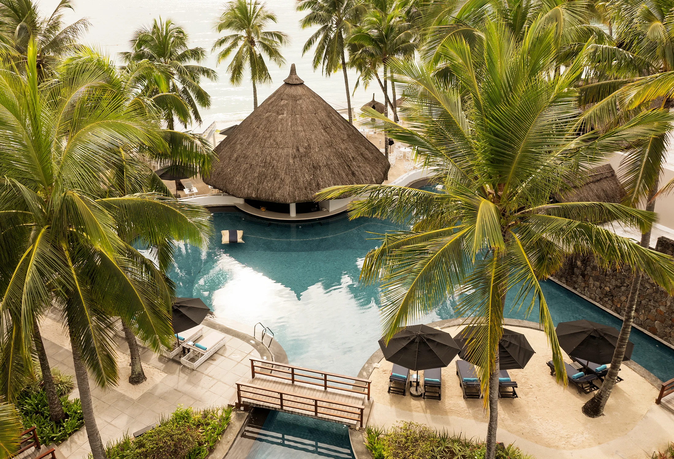 Tropisches Resort mit Pool und Palmen bei Constance Hotels & Resorts auf Mauritius – perfekte Kulisse für Honeymoon und Flitterwochen