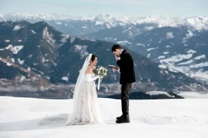Emotionaler Moment bei einer Winterhochzeit in den Bergen, während der Bräutigam gerührt seine Worte vorliest.