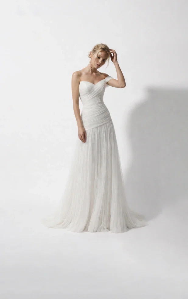 Feine Tüllfalten verlaufen elegant über das Oberteil und betonen die Taille, während der luftige Rock für einen zarten, verträumten Look sorgt. Von Lili Pelligrino.